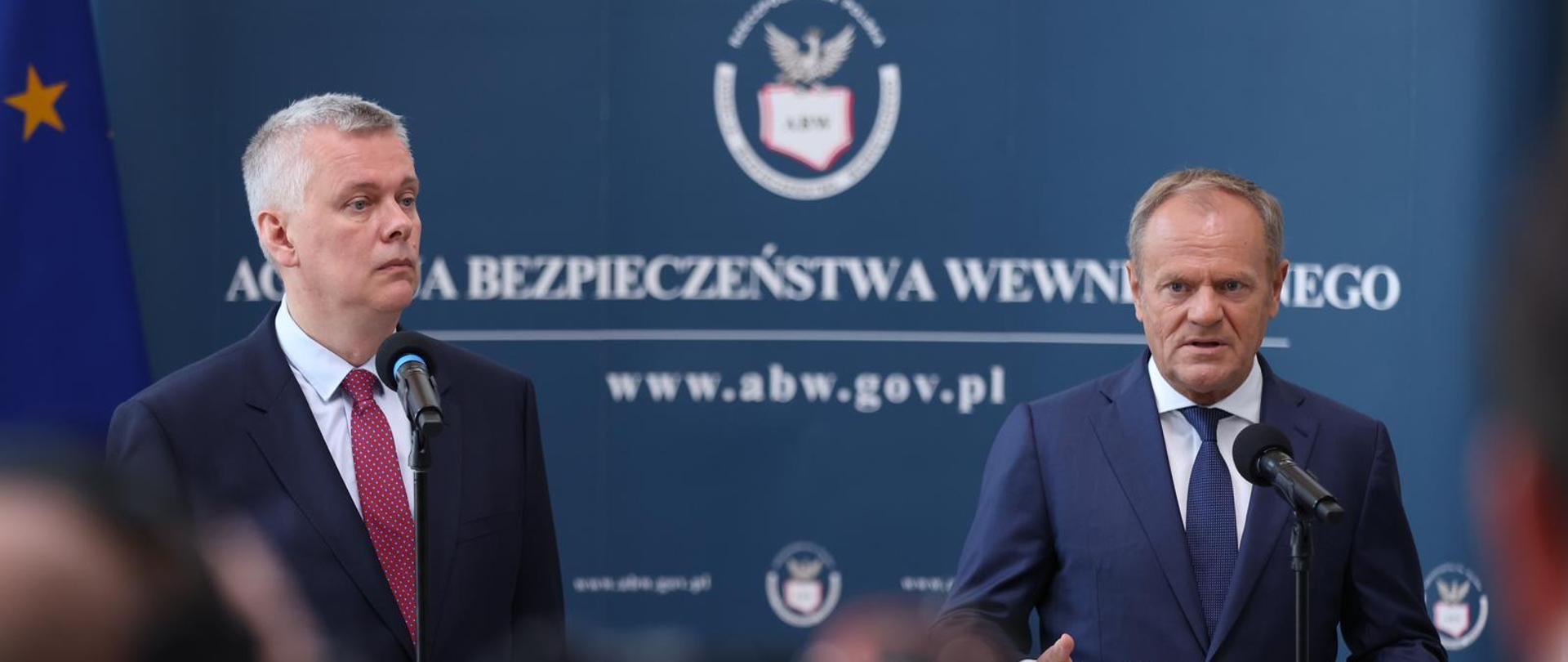 Premier Donald Tusk i Minister Spraw Wewnętrznych i Administracji na tle ścianki z logo ABW podczas konferencji prasowej