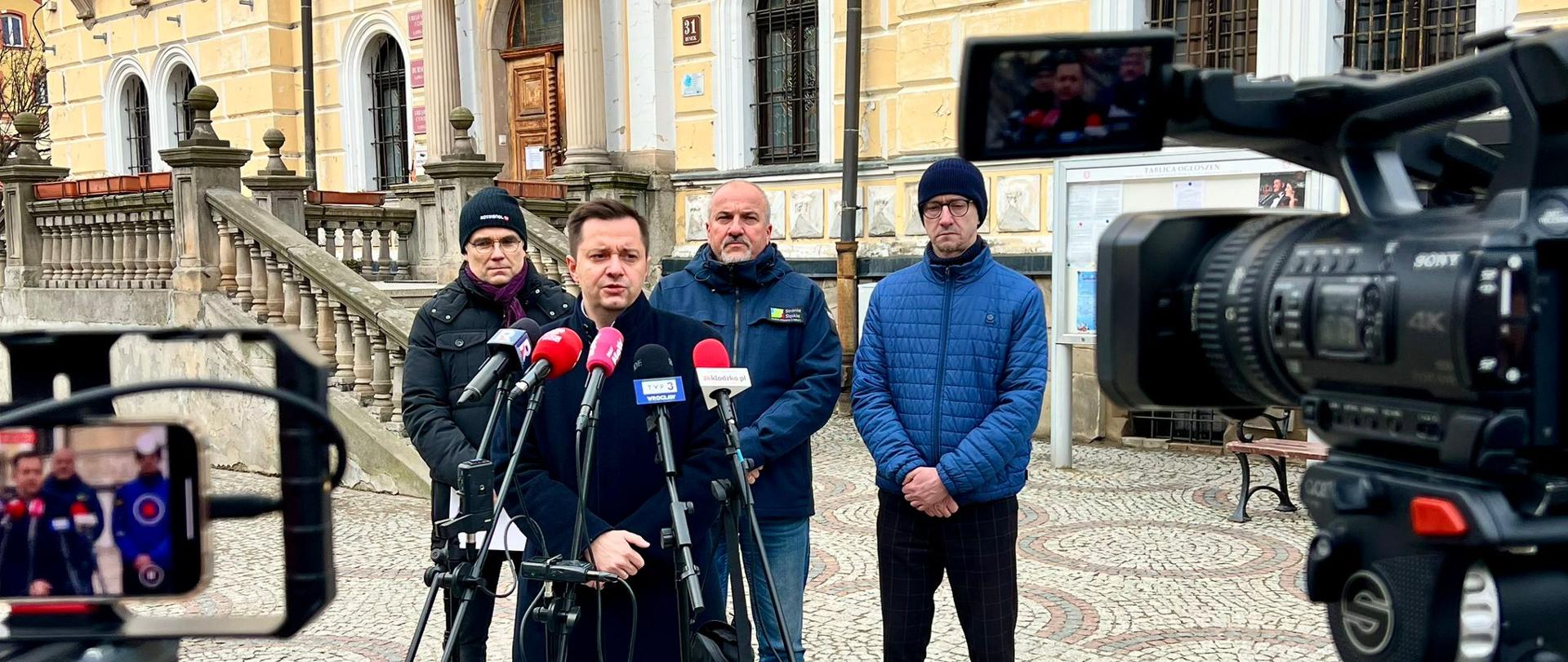 Briefing prasowy w Lądku Zdroju z udziałem Mateusza Balcerowicza - Wiceprezesa Wód Polskich. W tle od lewej: Jacek Drabiński - Wicedyrektor RZGW we Wrocławiu, Dariusz Chromiec - Burmistrz Stronia Śląskiego, Tomasz Nowicki - Burmistrz Lądka Zdroju.
