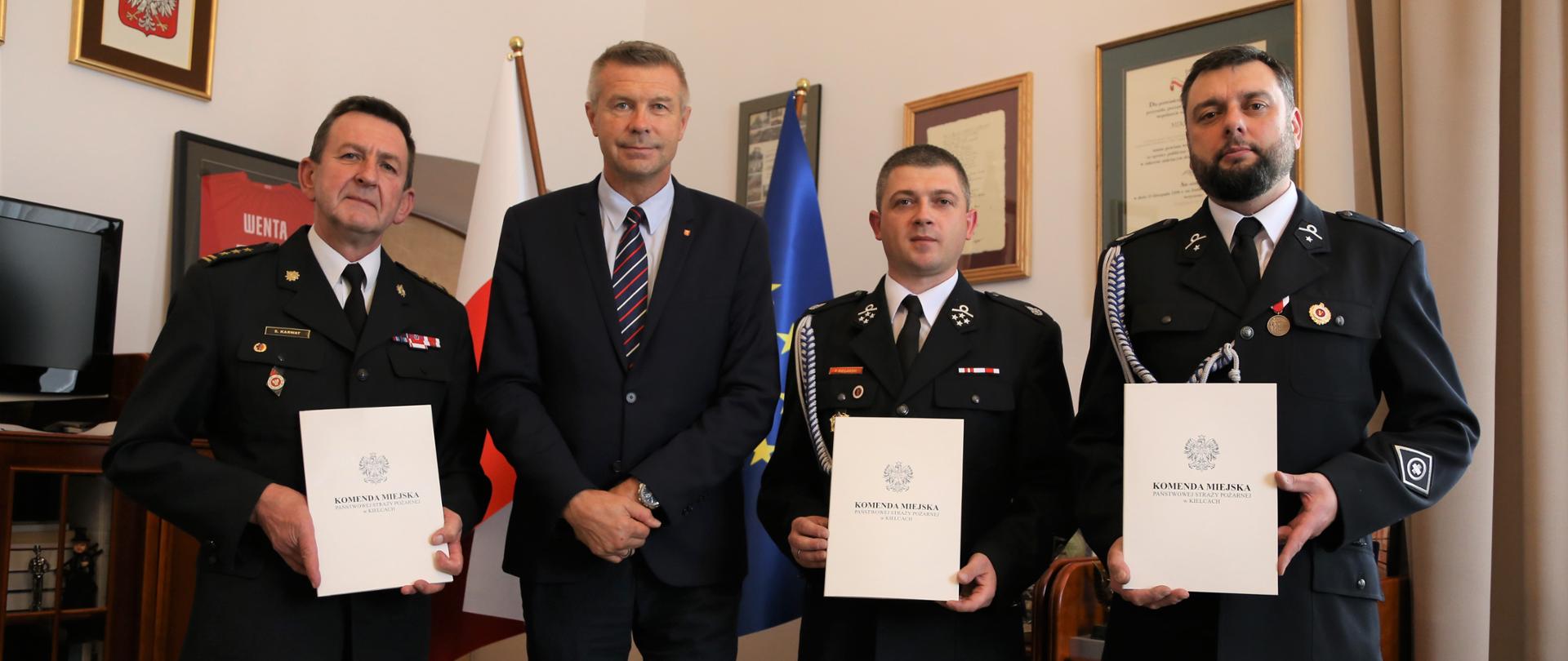 Zdjęcie przedstawia Komendanta Miejskiego PSP wraz z Prezydentem miasta Kielce oraz przedstawicieli OSP Niewachlów. Trzymają Oni w rękach podpisane porozumienie.