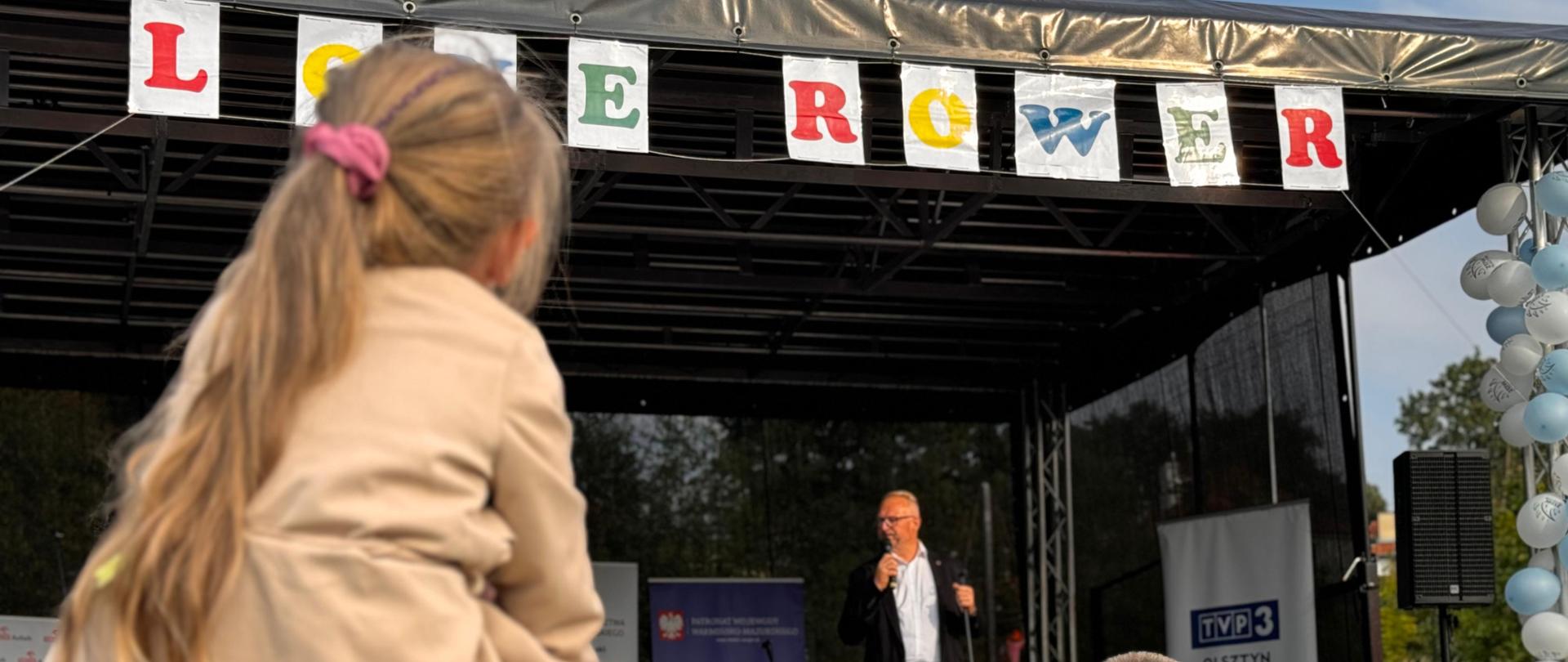 Piknik edukacyjny Love Rower - 15 września 2024 r. - Wojewoda Warmińsko-Mazurski Radosław Król na scenie podczas wystąpienia. 