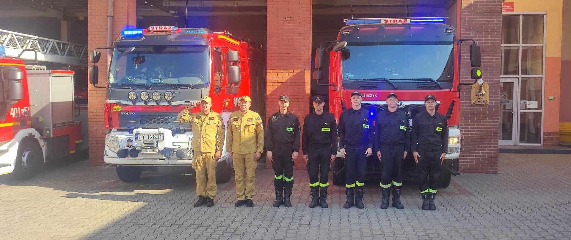 Zdjęcie przedstawia strażaków na placu przed Komendą oddających hołd w 80. rocznicę wybuchu powstania warszawskiego.
W tle samochody strażackie oraz budynek Jednostki Ratowniczo - Gaśniczej.
