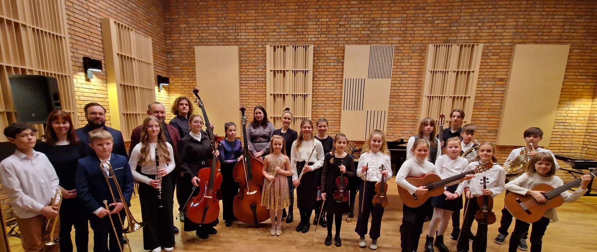 Uczniowie i nauczyciele z instrumentami