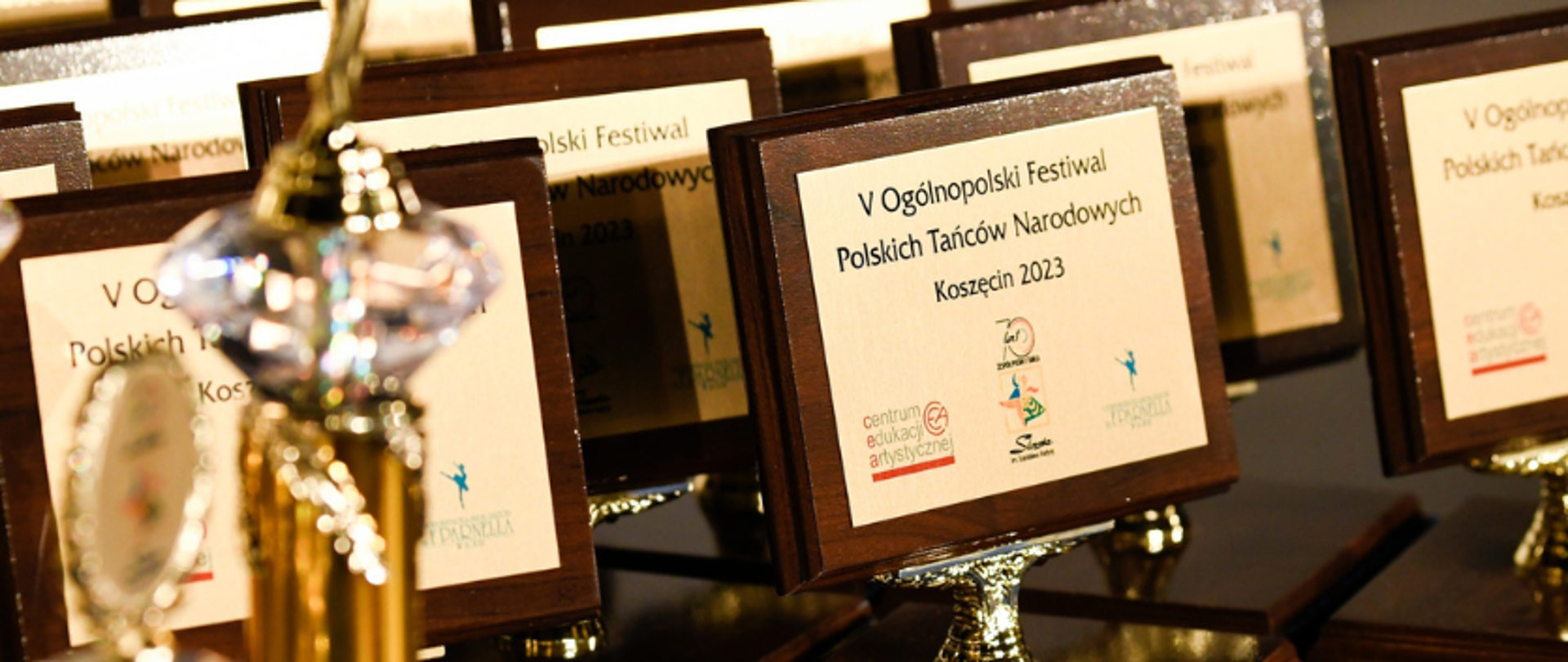 zdjęcie: nagrody i statuetki przyznawane w V Ogólnopolskim Festiwalu Polskich Tańców Narodowych dla Uczniów Ogólnokształcących Szkół Baletowych ustawione na stole