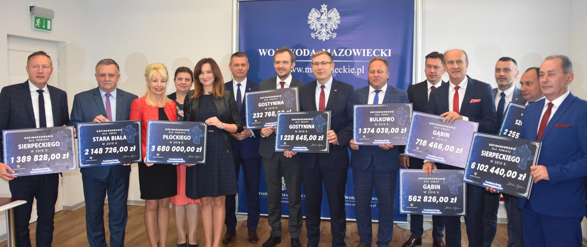 Wspólne zdjęcie beneficjentów Funduszu Dróg Samorządowych z Senatorem RP Markiem Martynowskim, Posłem na Sejm RP Maciejem Małeckim, Wicewojewodą Arturem Standowiczem oraz Kierownikiem delegatury MUW w Płocku Marleną Mazurską. Spotkanie odbyło się w Delegaturze MUW w Płocku.