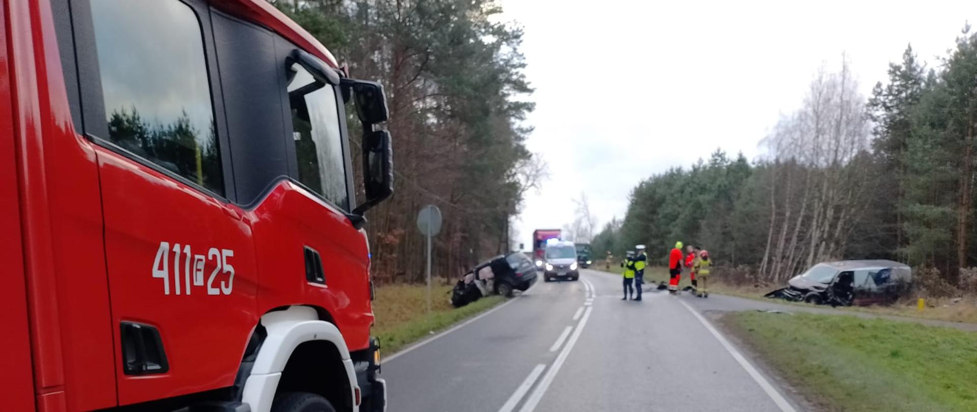 w tle samochody po zderzeniu, na pierwszym planie samochód strażacki