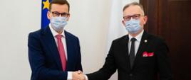 Uścisk dłoni, premier Mateusz Morawiecki i z-ca szefa KAS Mariusz Gojny.