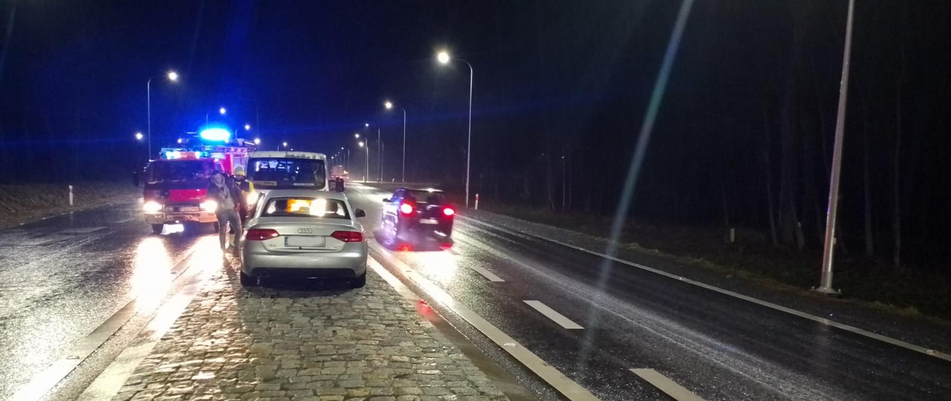 Samochód osobowy na wysepce rozdzielającej pasy ruchu i samochody pożarnicze