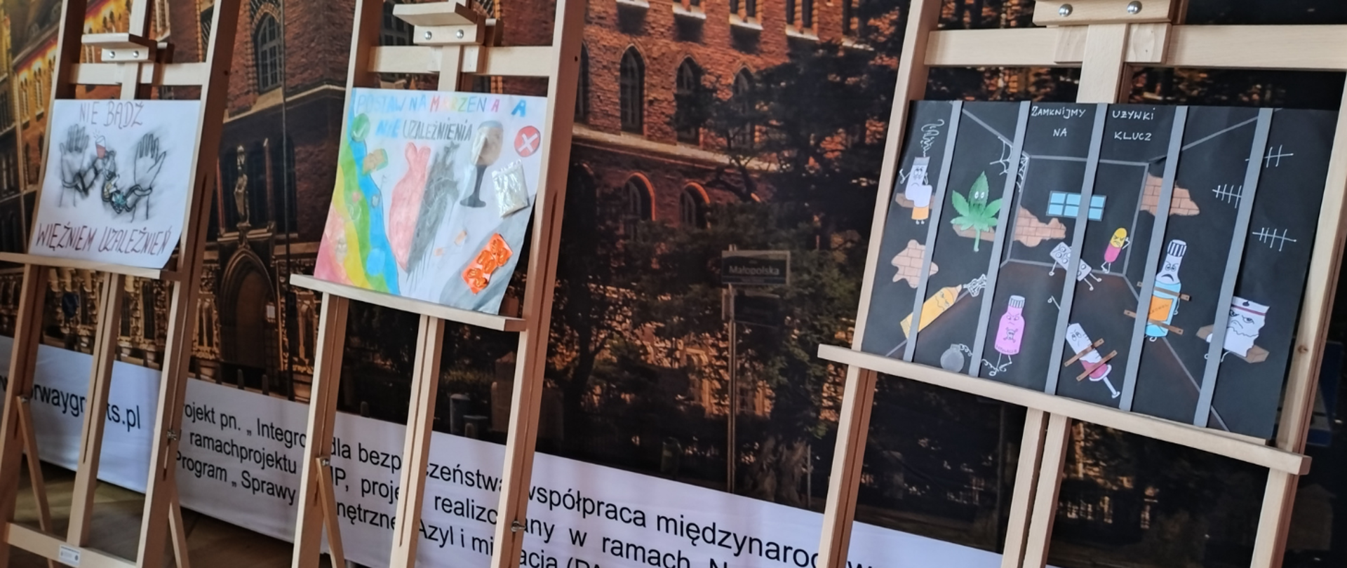 Grafika przedstawia wystawę prac laureatów konkursu plastycznego na plakat pod hasłem: „Artystycznie o uzależnieniach”.