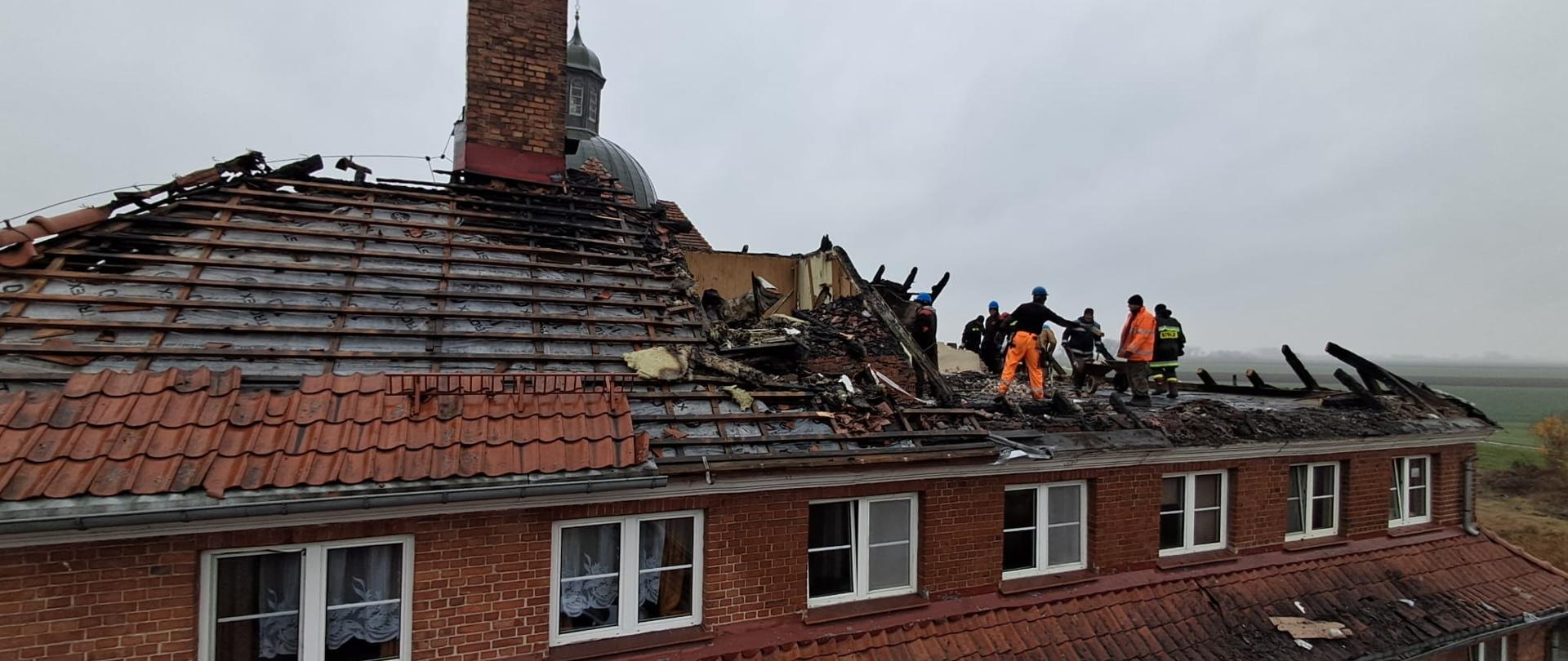 Na zdjęciu budynek z cegły, który ma uszkodzony dach po pożarze.