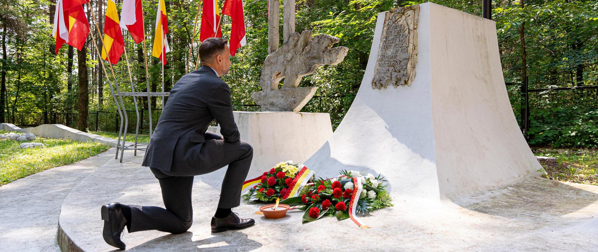 Wojewoda Jacek Brzozowski składa kwiaty na symbolicznym grobie ofiar masowych hitlerowskich egzekucji w Lesie Bacieczki