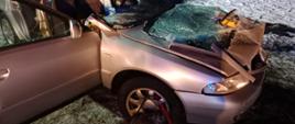 Na zdjęciu widać uszkodzony srebrny samochód który brał udział w wypadku.