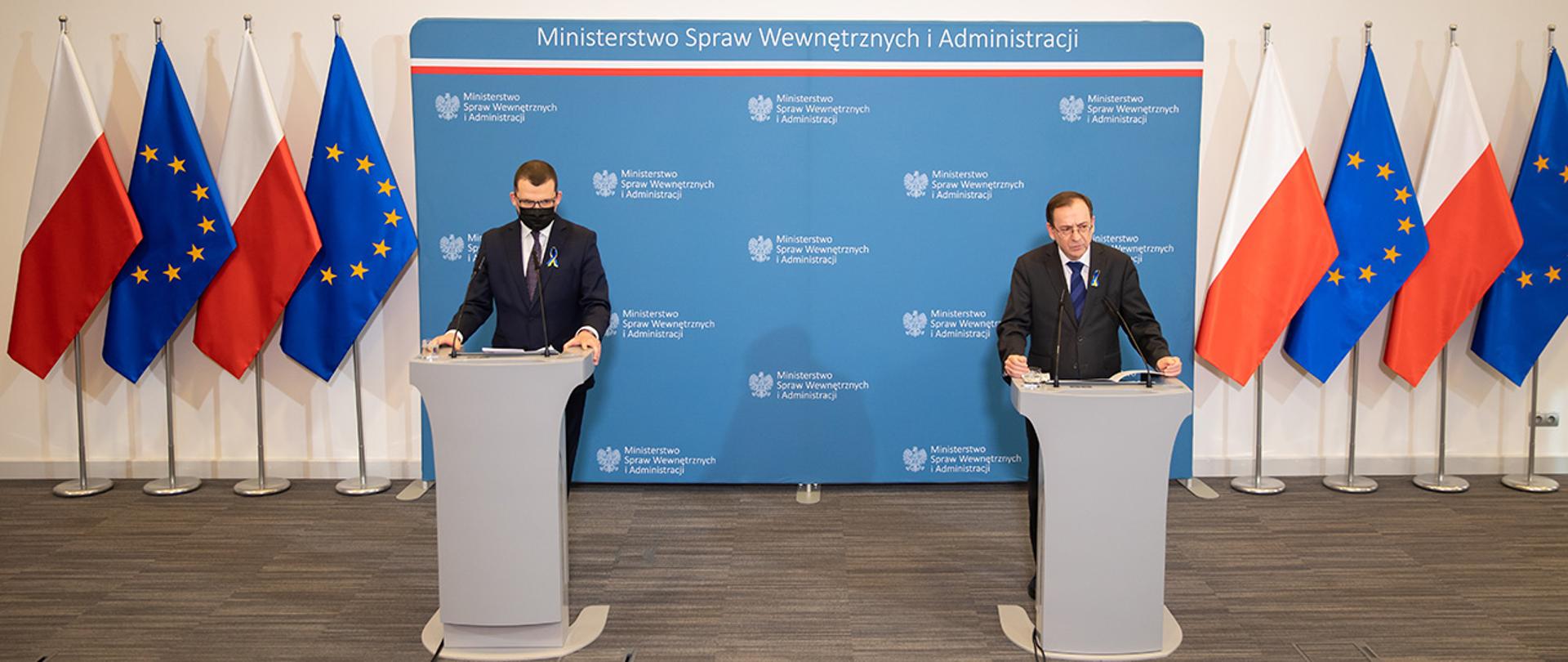 Minister Mariusz Kamiński and Paweł Szefenaker standing at the rostrums during a press conference at the Ministry of Interior and Administration.