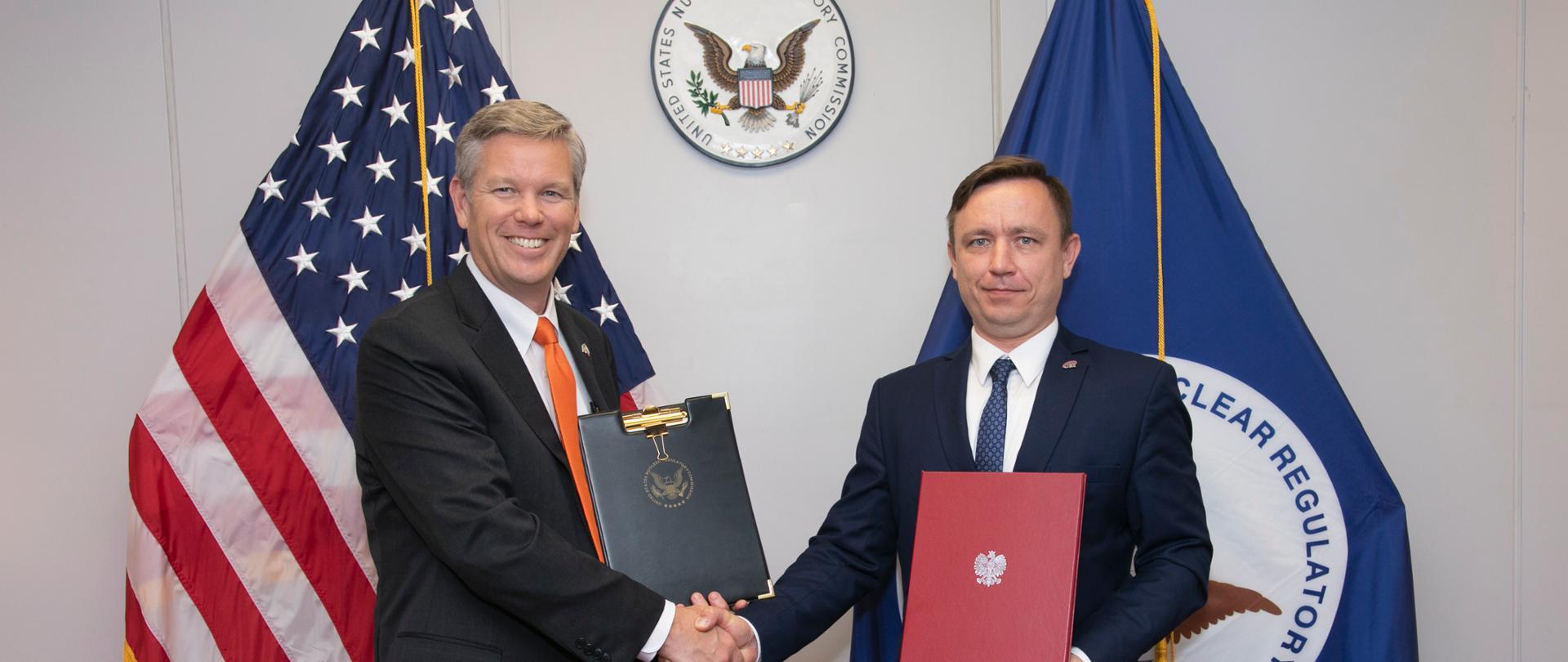 Chairman of the United States Nuclear Regulatory Commission (US NRC) Christopher Hanson and President of the National Atomic Energy Agency Andrzej Głowacki shake hands after signing a cooperation agreement