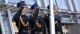 zdjęcie przedstawia trzech funkcjonariuszy salutujących w mundurach galowych.