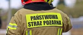 Napis Państwowa Straż Pożarna na plecach strażaka