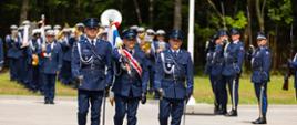 Policjanci niosący sztandar 