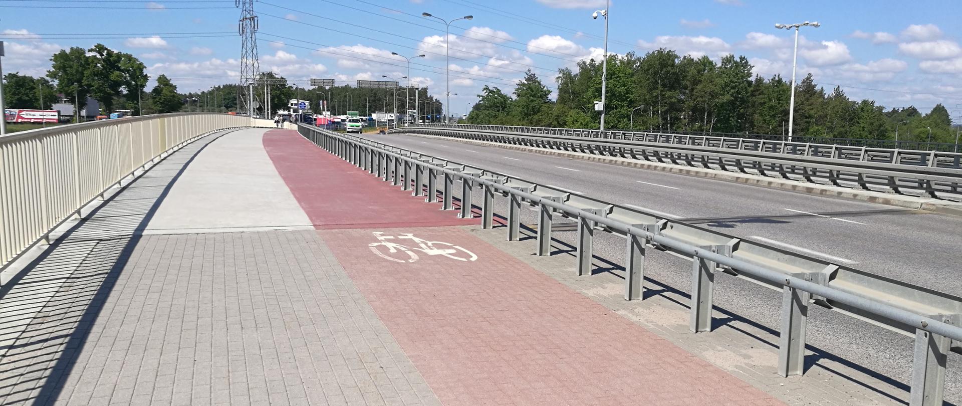 Zdjęcie przedstawia wiadukt w ciągu ul. Słowackiego na węźle Gdańsk Lotnisko na S6 Obwodnicy Trójmiasta. Na pierwszym planie jest chodnik ze ścieżką rowerową, a dalej jezdnia.
