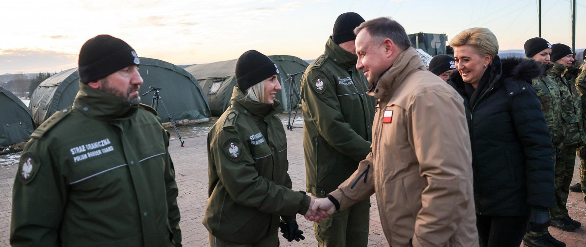 Prezydent Andrzej Duda ściska dłoń funkcjonariuszce Straży Granicznej.