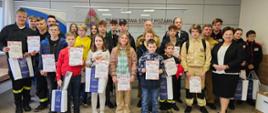 Pamiątkowe zdjęcie uczestników oraz organizatorów eliminacji powiatowych Ogólnopolskiego Turnieju Wiedzy Pożarniczej "Młodzież Zapobiega Pożarom" w Środzie Wielkopolskiej