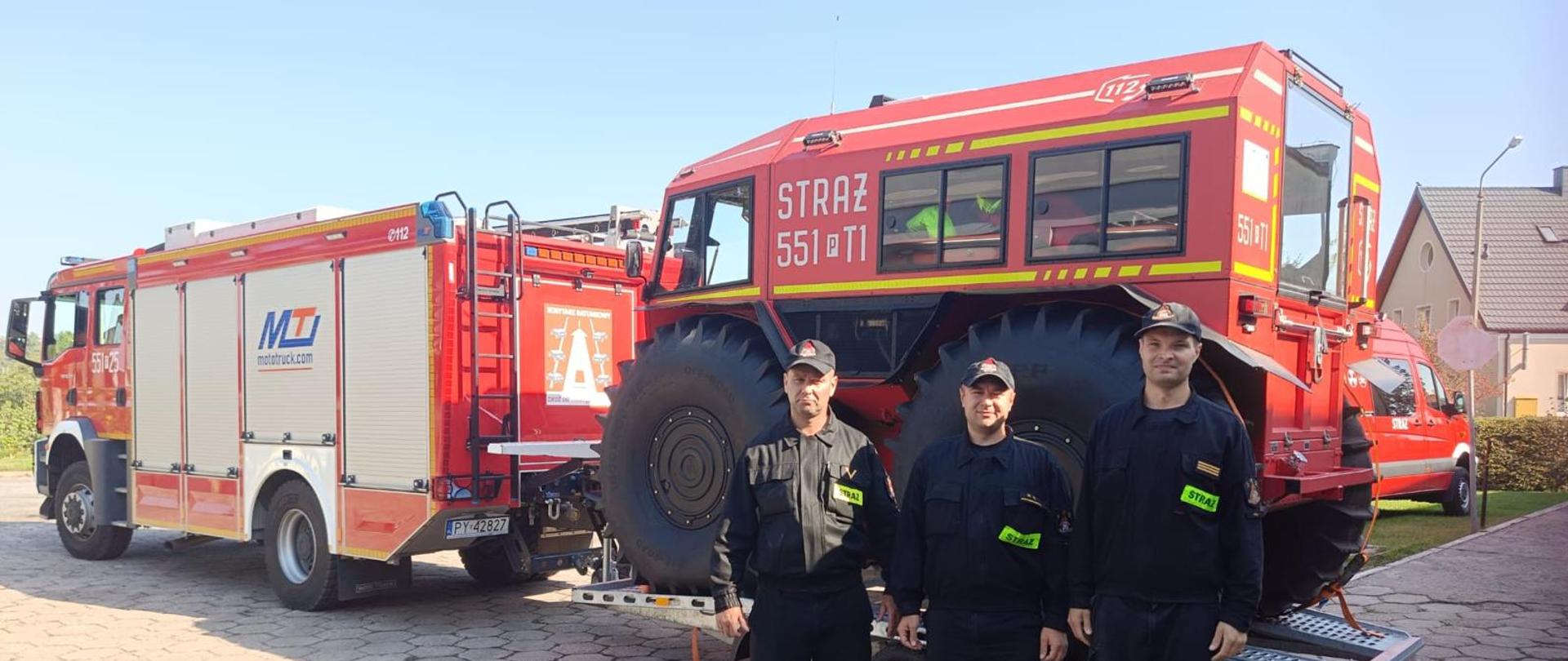 Trzech strażaków, samochód gaśniczy oraz pojazd specjalistyczny.