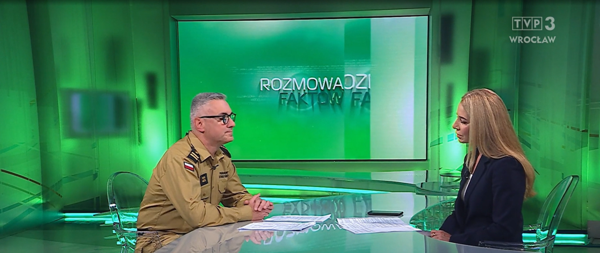 umundurowany strażak w studio tv wraz z redaktorką podczas wywiadu