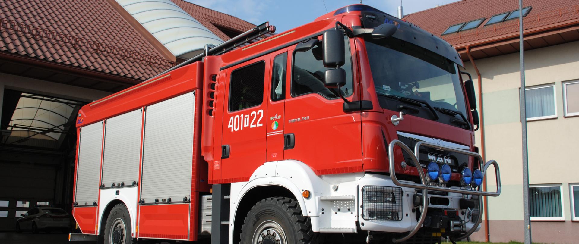 Czerwony samochód pożarniczy na tle budynku KP PSP w Busku Zdroju 