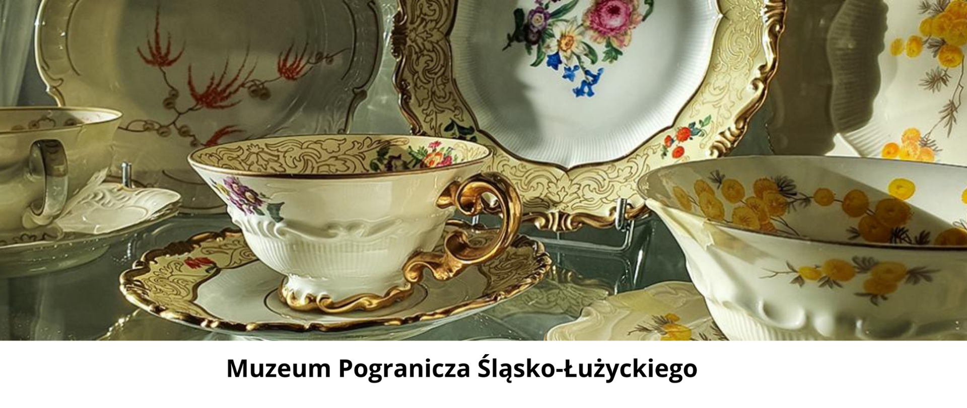 Grafika w postaci porcelany różnokolorowe filiżanki oraz talerze . Motywy kwiatowe w różnych kolorach. Napis na białym tle Muzeum Pogranicza Śląsko-Łużyckiego