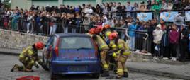 Strażacy w ramach pokazów ratowniczych uwalniają z samochodu osobę poszkodowaną