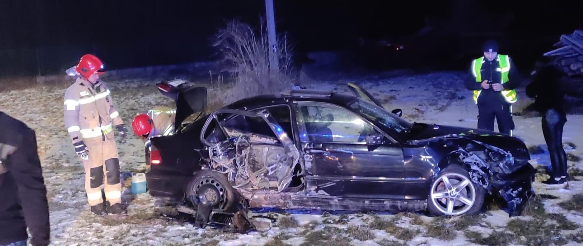 Wypadek samochodu osobowego miejscowość Cudzynowice – ratownicy prowadzący rozpoznanie wokół rozbitego samochodu.