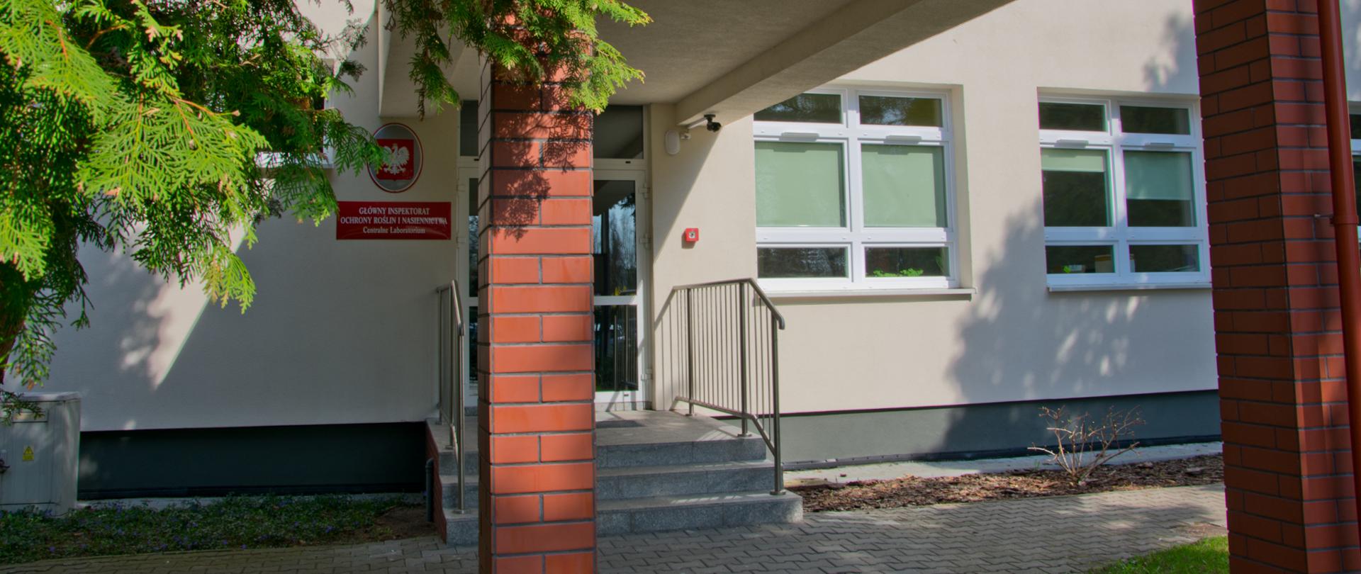 Zdjęcie przedstawia drzwi wejściowe do budynku Centralnego Laboratorium w Toruniu