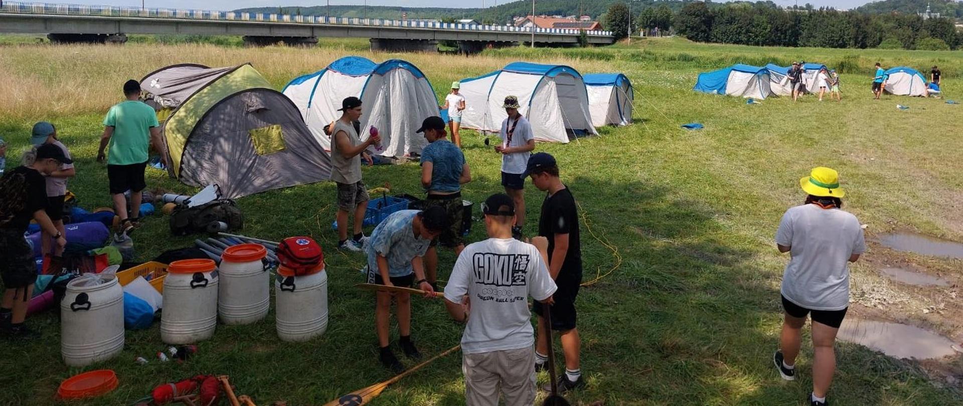 Zdjęcie przedstawia uczestników obozu organizujących sobie obozowisko. 