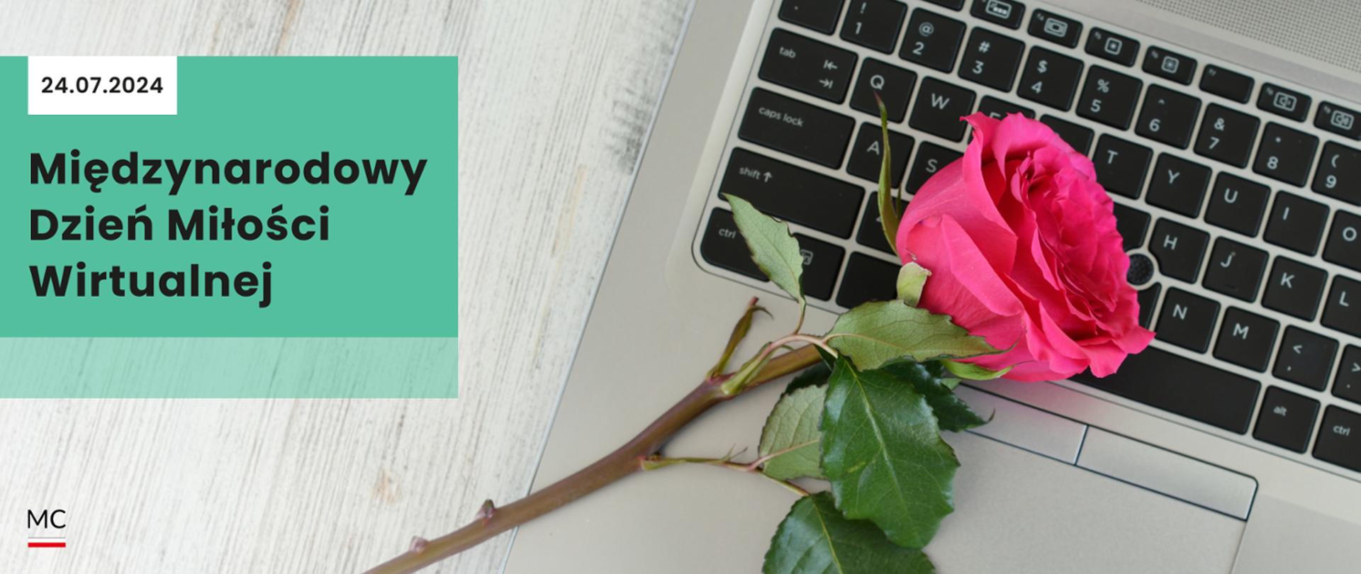 Napis: Międzynarodowy Dzień Miłości Wirtualnej w tle laptop i różowa róża
