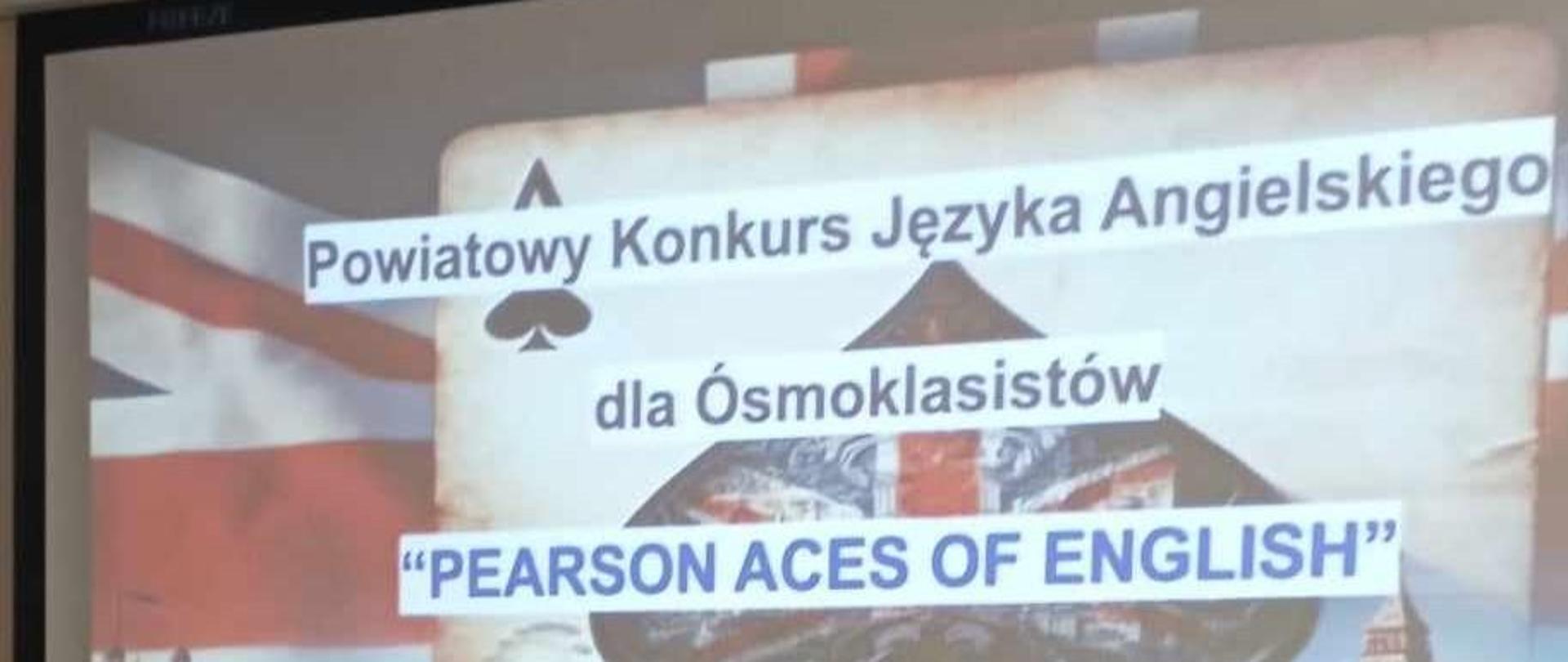 Dwie uczennice z dyplomami w ręku, w tle plakat Powiatowego Konkursu Języka Angielskiego dla Ósmoklasistów "Pearson Aces of English"