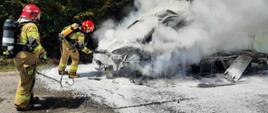 Strażacy gaszą pianą palący się samochód dostawczy