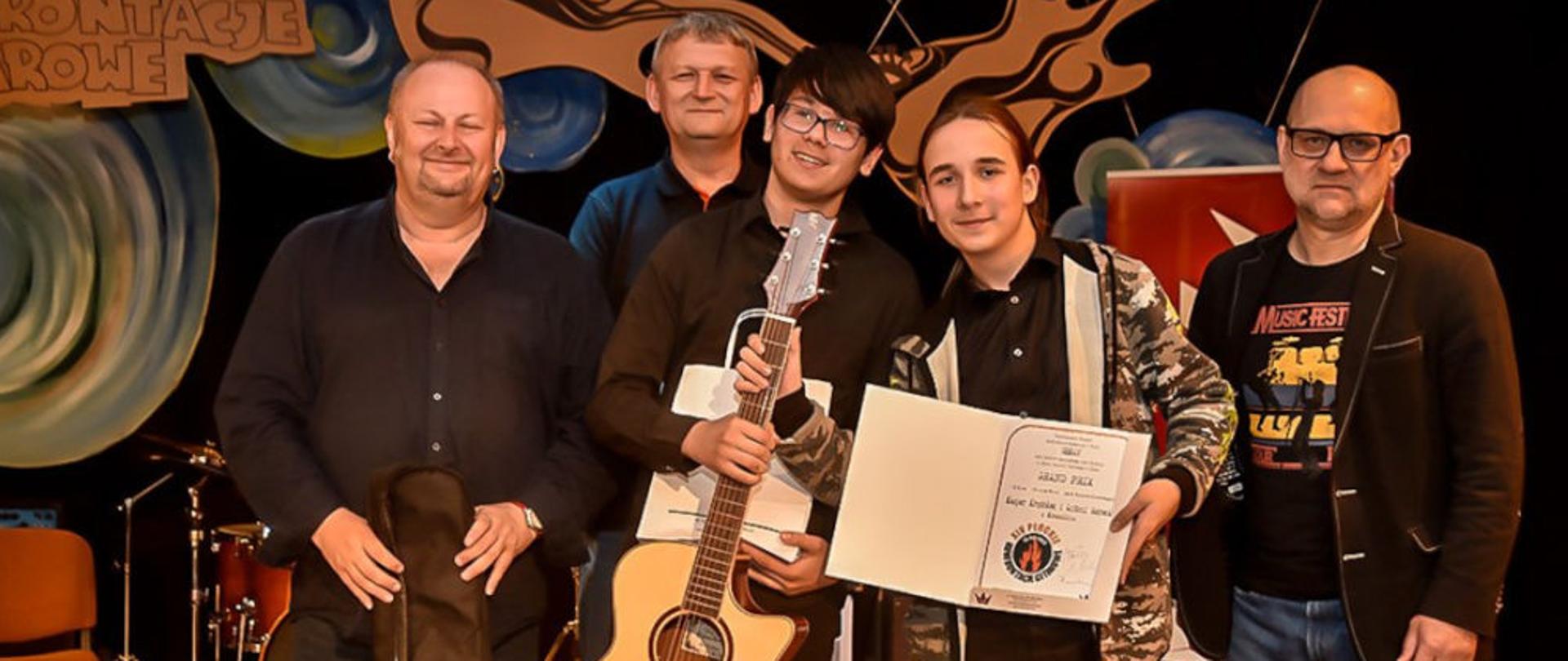 Na zdjęciu uczniowie z dyplomem oraz trzech innych gitarzystów.