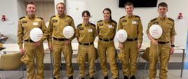 Pamiątkowe zdjęcie organizatorów akcji pozyskiwania dawców szpiku kostnego i macierzystych komórek krwiotwórczych.
sześć osób - strażacy w umundurowaniu służbowym - czterech trzyma białe balony z logo akcji. 