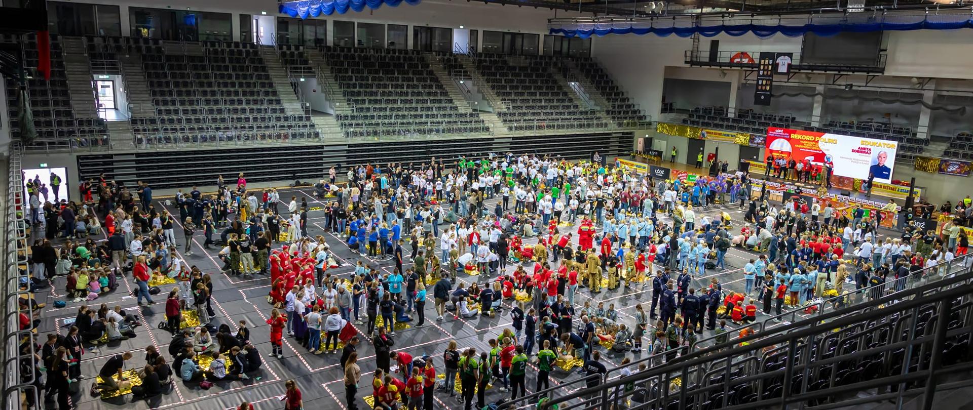 sala sportowa wypełniona ludźmi wykonujących resuscytację krążeniowo oddechową