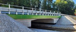 Fotografia przedstawia przebudowane obiekty nad rzeką Pagor w ciągu DK86, belki gzymsowe wykonano w kolorze zielonym, obiekt wyposażono m,. in. w bariery stalowe