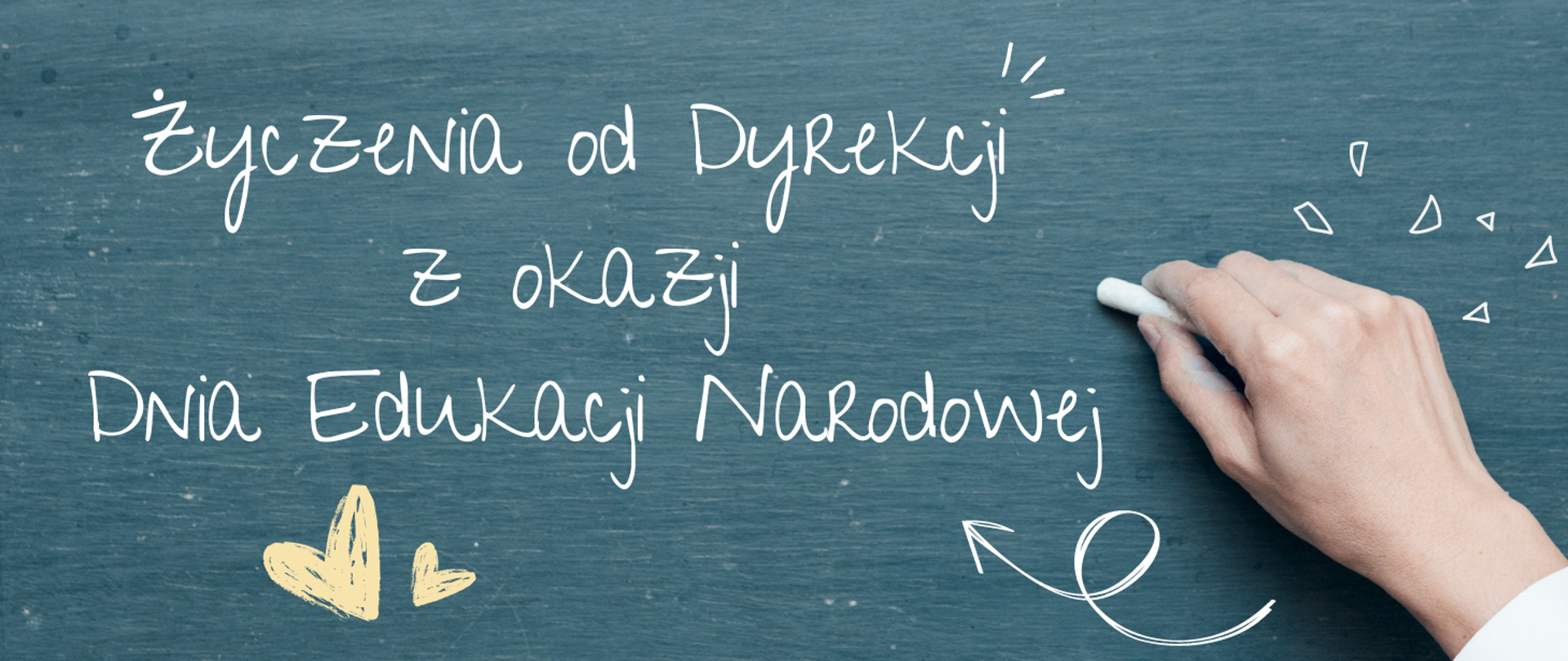 w centralnej części biały napis:"Życzenia od Dyrekcji z okazji Dnia Edukacji Narodowej", poniżej dwa żółte serca, w prawym dolnym rogu dłoń trzymająca kredę, całość na niebieskim tle