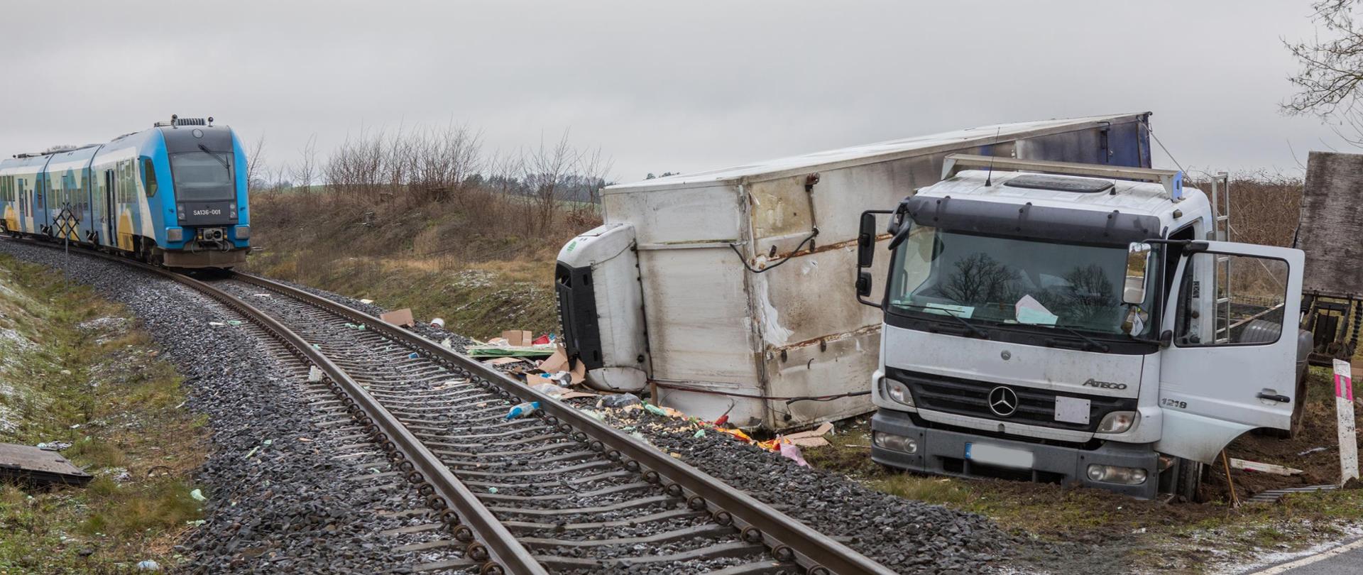 Zdjęcie przedstawia strażaków w trakcie akcji związanej z uderzeniem szynobusa w samochód ciężarowy