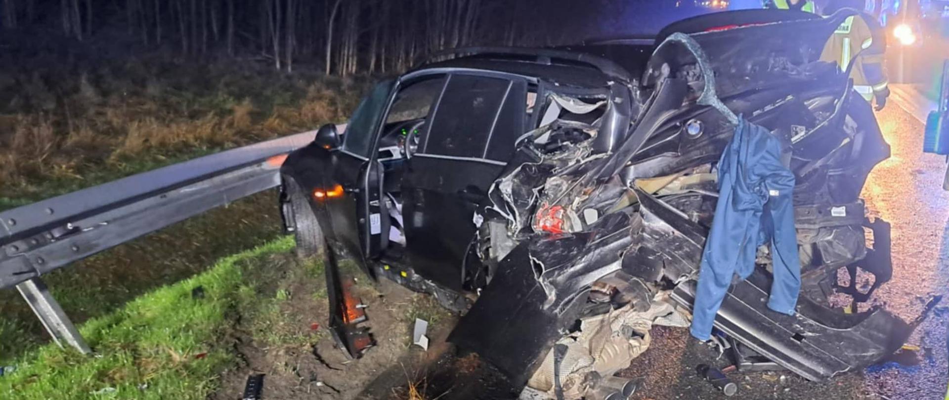 Na zdjęciu znajduje się wrak pojazdu. Pojazd na poboczu z znacząco uszkodzonym tyłem.