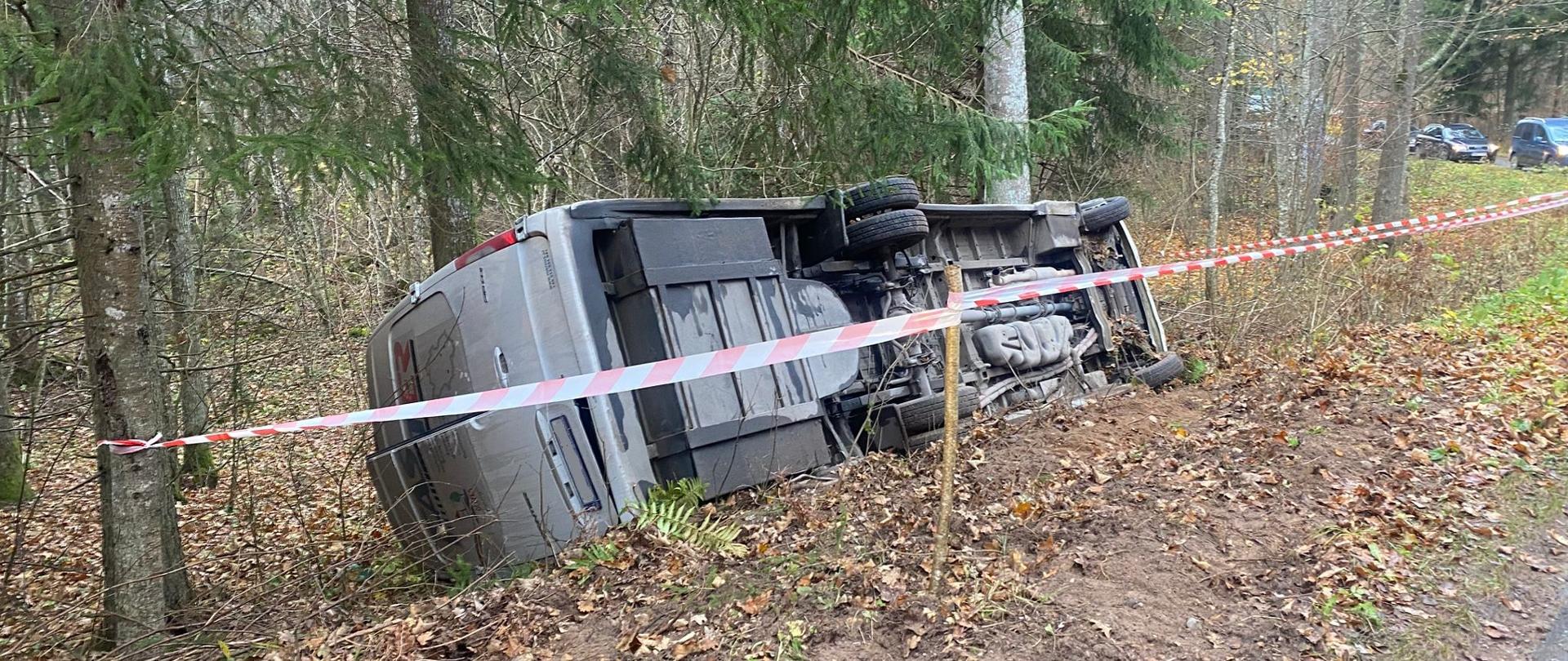 Na zdjęciu widać pojazd bus, który leży na poboczu drogi.