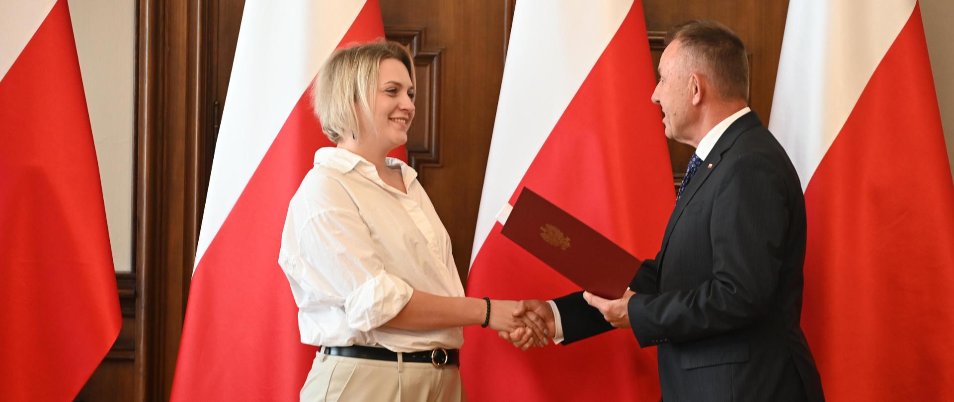 Wojewoda Łódzki Karol Młynarczyk wręcza akt nadania obywatelstwa polskiego 