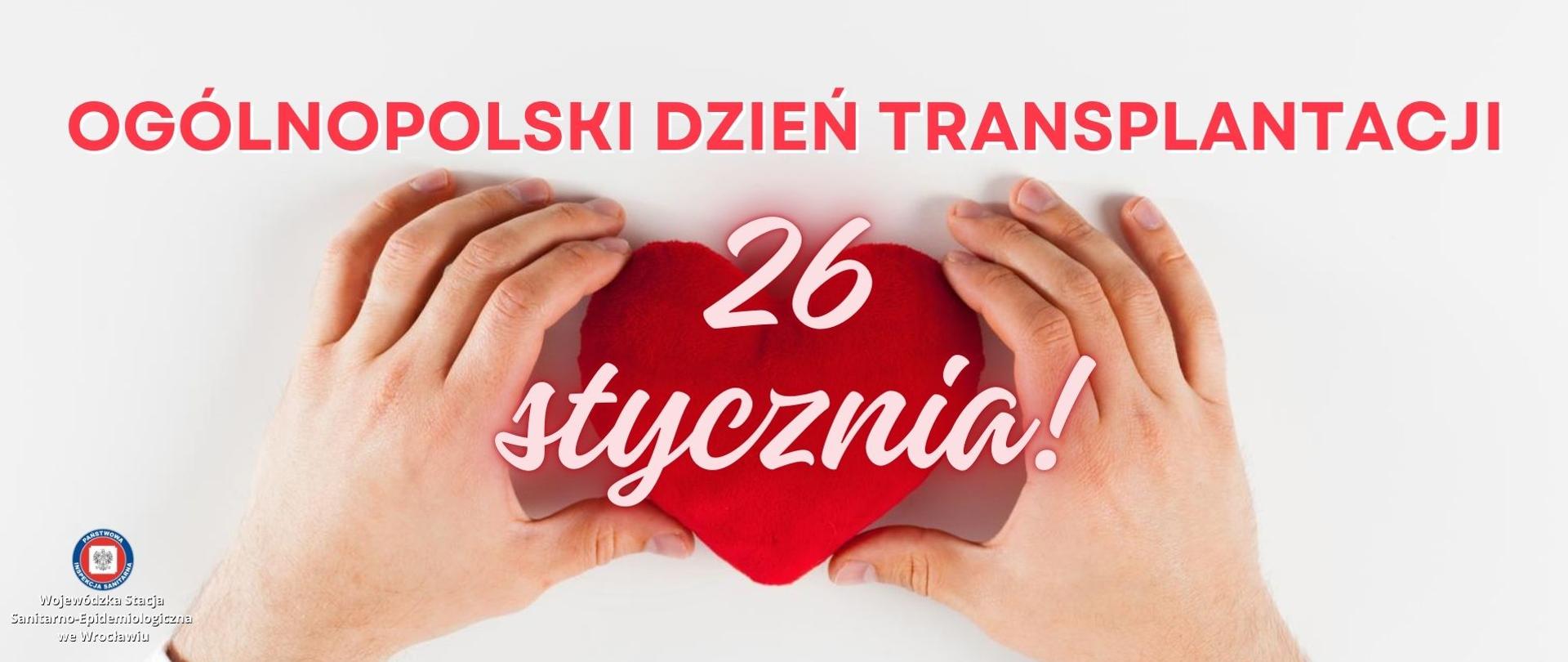 Dłonie trzymające na stole pluszowe czerwone serce