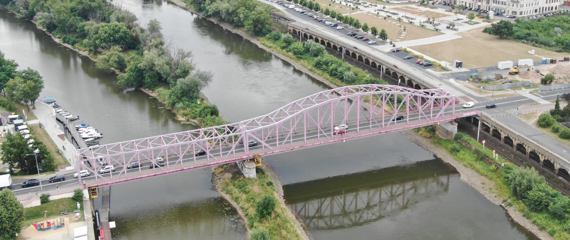 Most nad rzeką. W tle budynki miasta, dookoła dużo zieleni