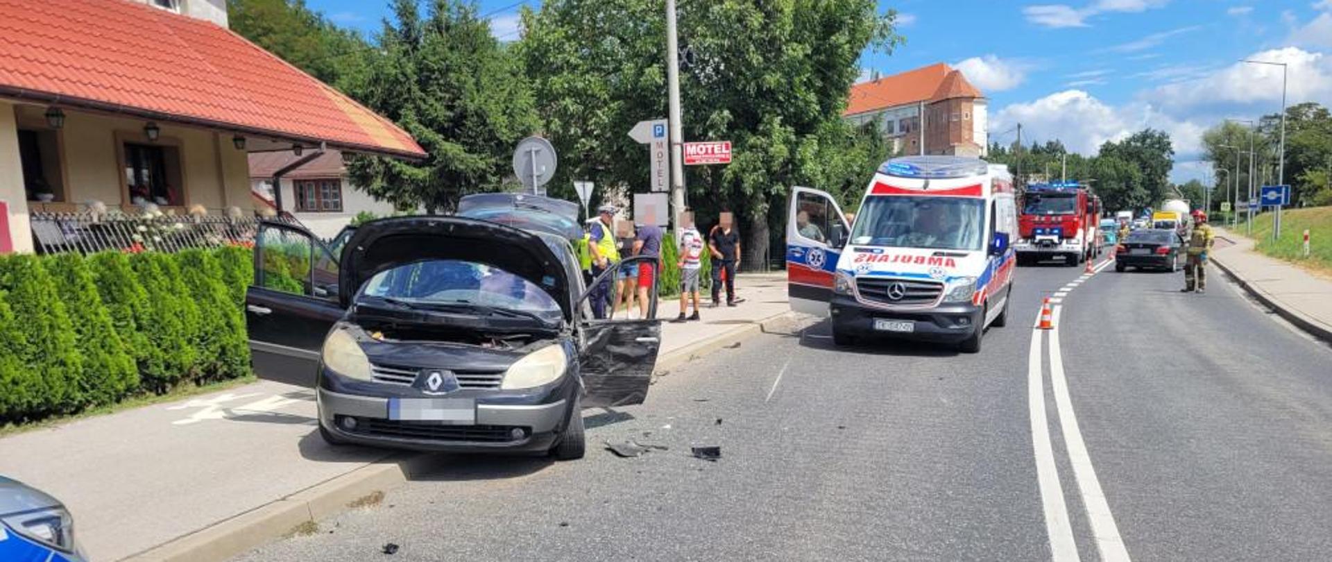 W tle widać ambulans, samochód biorący udział w zdarzeniu a także strażaków pracujących na miejscu zdarzenia