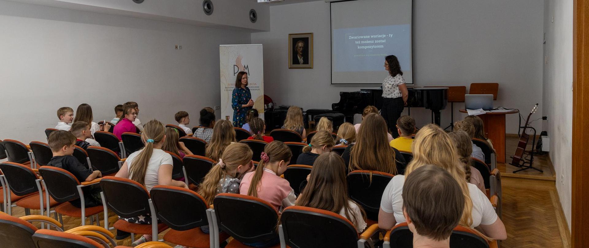 Koncert i warsztaty kompozytorskie 2024. Pani Agnieszka Niesler prowadząca warsztaty kompozytorskie. Uczniowie zgromadzeni na warsztatach w auli PSM w w Głubczycach.