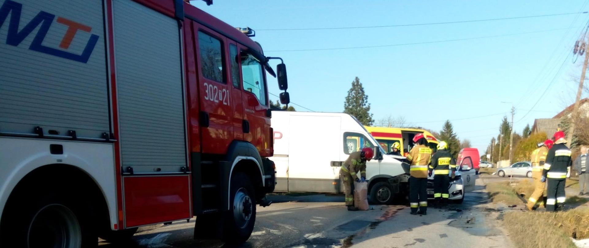 Zdjęcie przedstawia miejsce wypadku: z lewej strony stoi samochód gaśniczy, a w głębi samochody, które uległy zderzeniu.