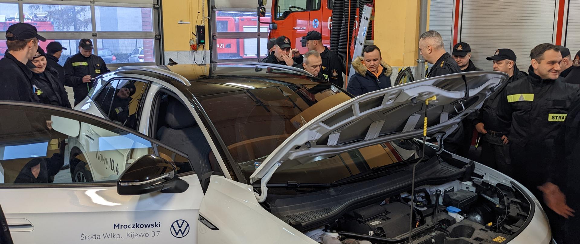 Strażacy JRG Środa Wielkopolska oglądają pojazd elektryczny VW ID 4 pod kątem występowania zagrożeń podczas ich pożarów