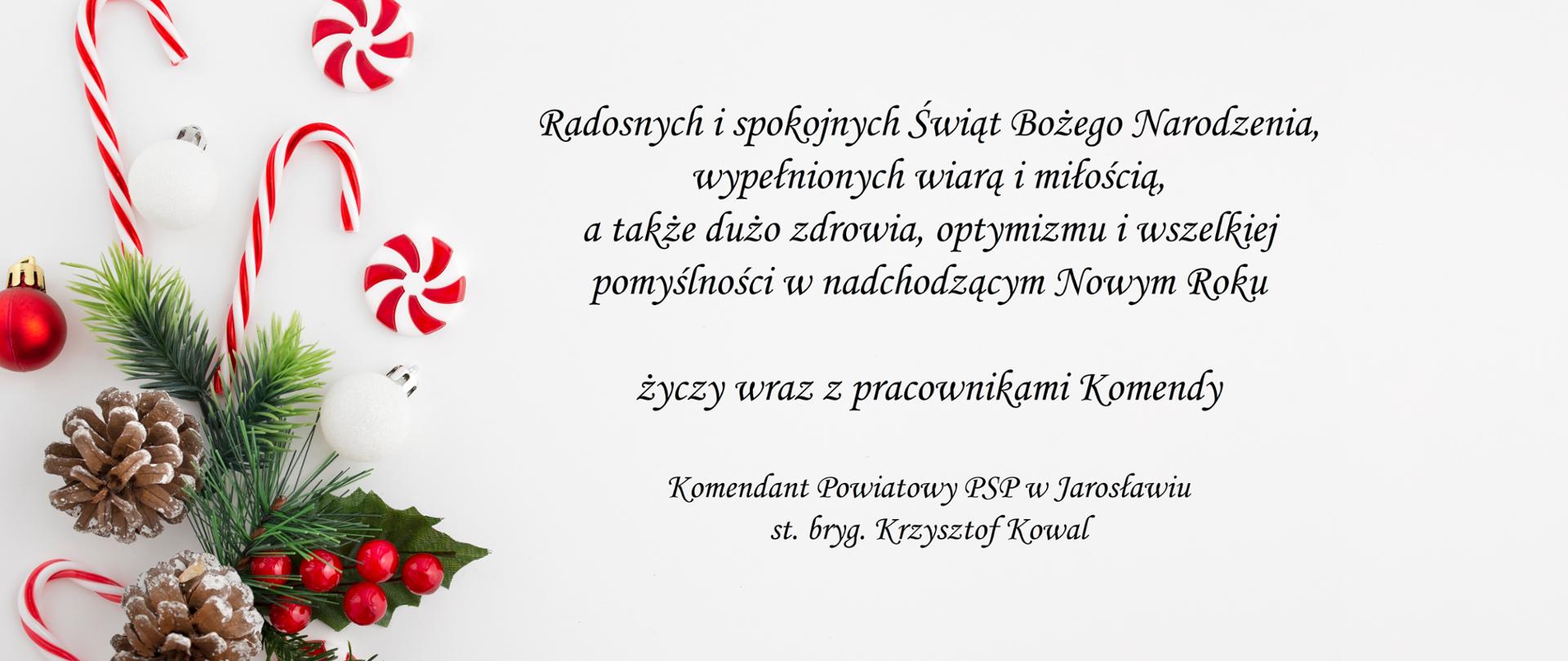 Po lewej stronie widać stroik świąteczny, a po prawej życzenia w formie wierszowanej o treści: "Radosnych i spokojnych Świąt Bożego Narodzenia, wypełnionych wiarą i miłością, a także dużo zdrowia, optymizmu i wszelkiej pomyślności w nadchodzącym Nowym Roku życzy wraz z pracownikami Komendy Komendant Powiatowy PSP w Jarosławiu st. bryg. Krzysztof Kowal".